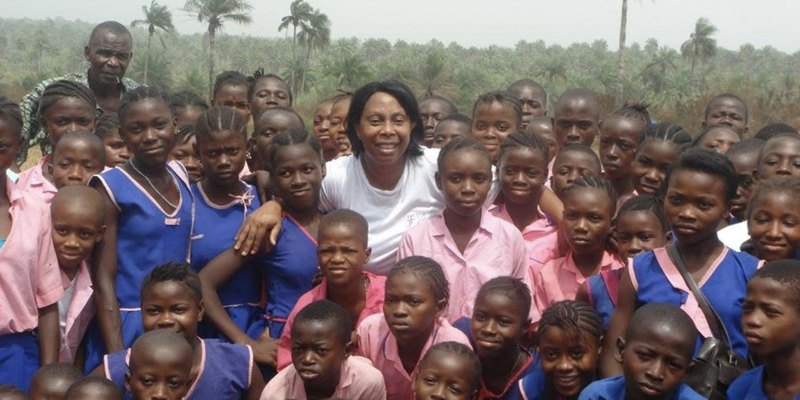 Pearl Jarrett surrounded by schoolchildren in Sierra Leone